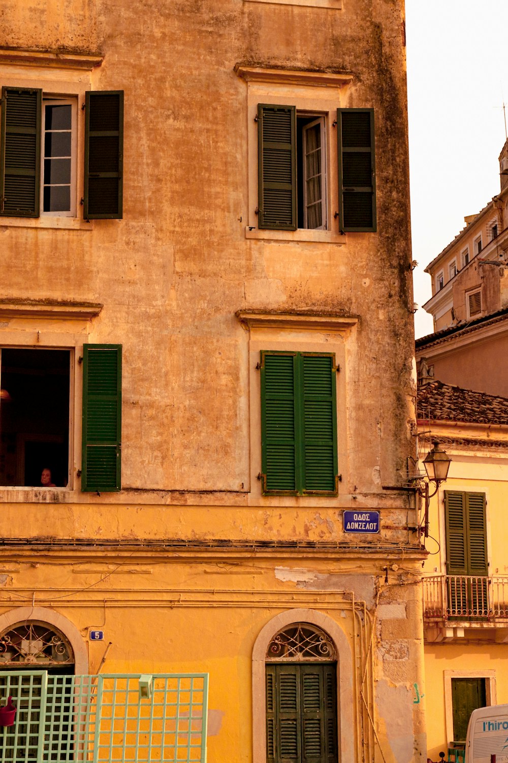 an old building with green shutters and a clock tower