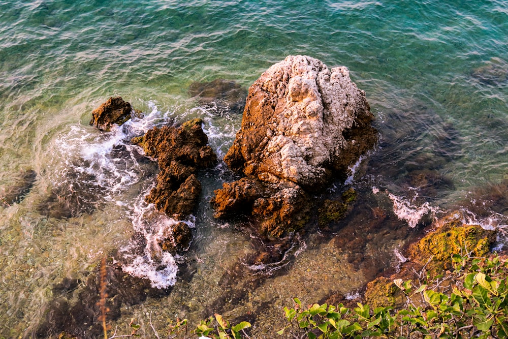 a rock formation in the water near the shore