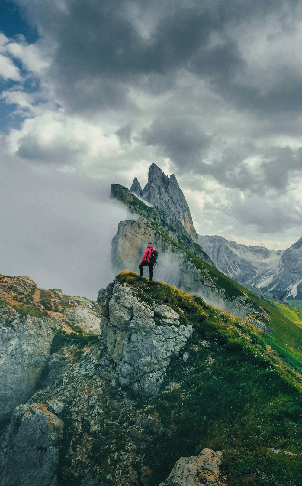 a man standing on top of a lush green hillside