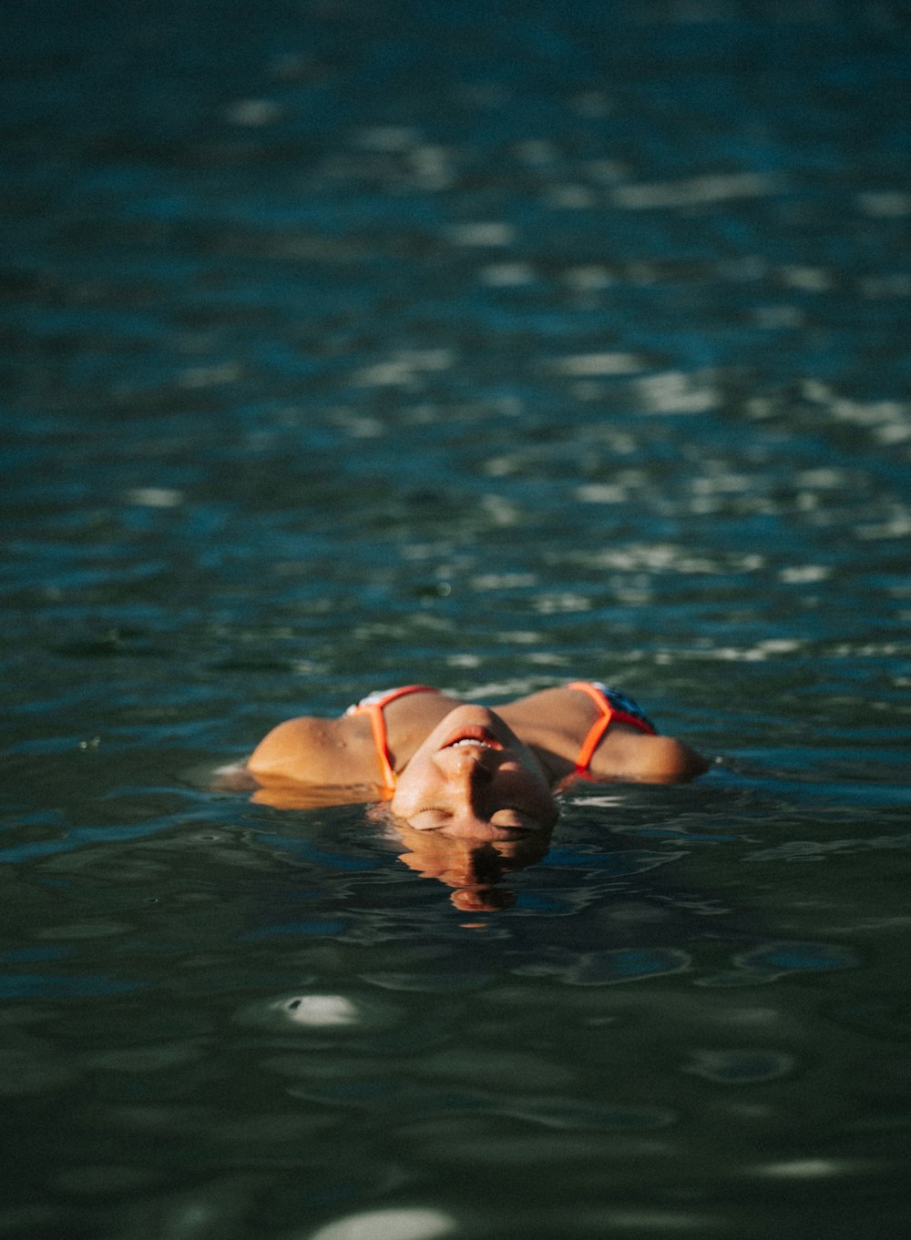 a woman floating on top of a body of water