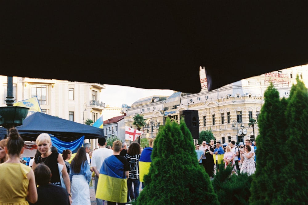 a crowd of people walking around a city street