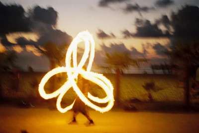 Fire dancers creating mesmerizing shapes at dusk during a festive celebration