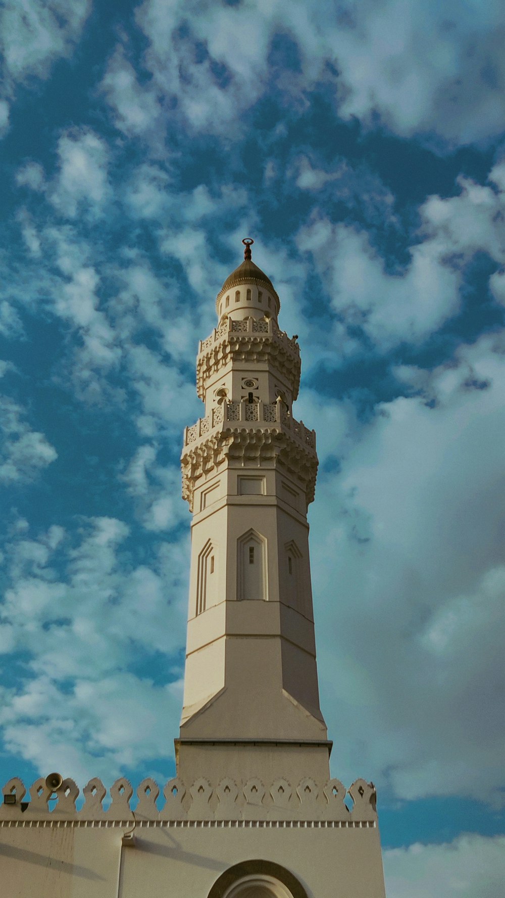 a tall white tower with a clock on it's side