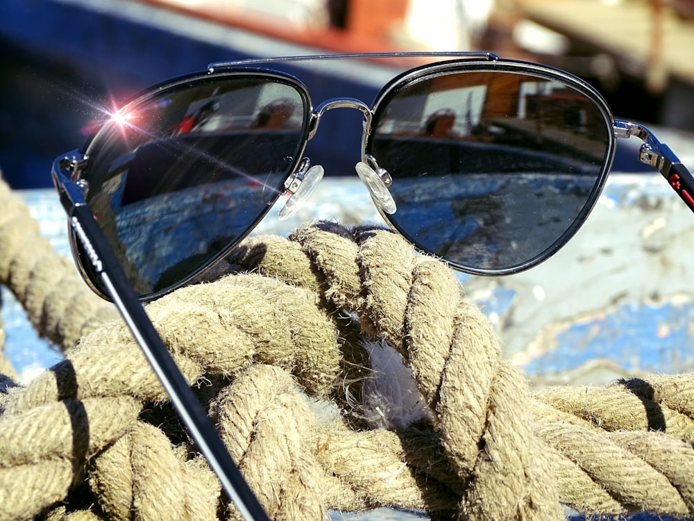 a pair of sunglasses sitting on top of a rope