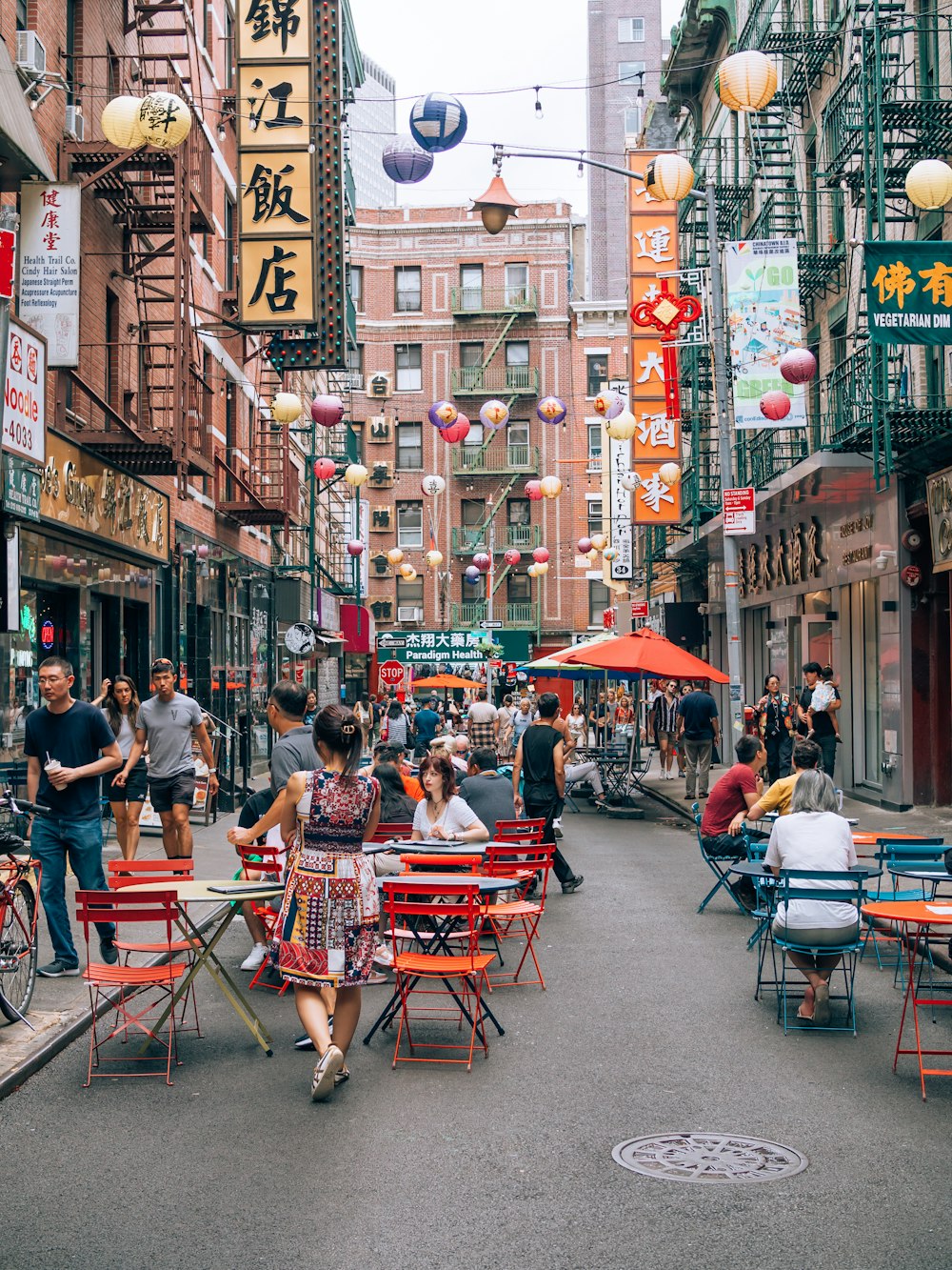 a group of people sitting at tables on a street