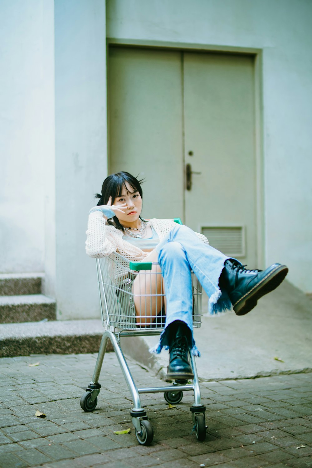 a woman sitting on top of a shopping cart