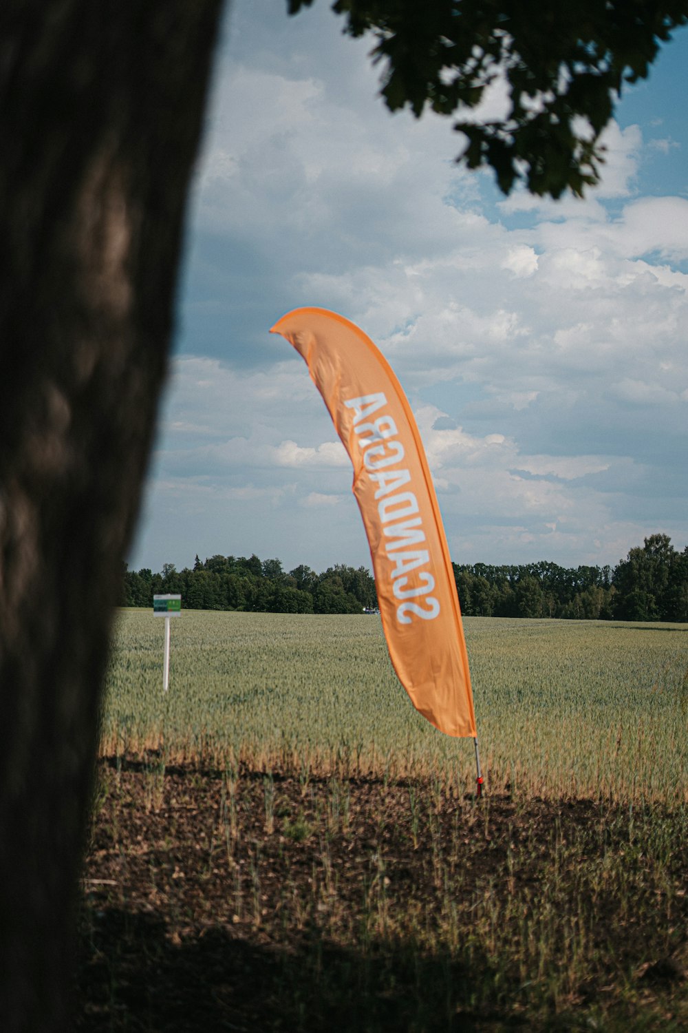 a large orange flag in the middle of a field