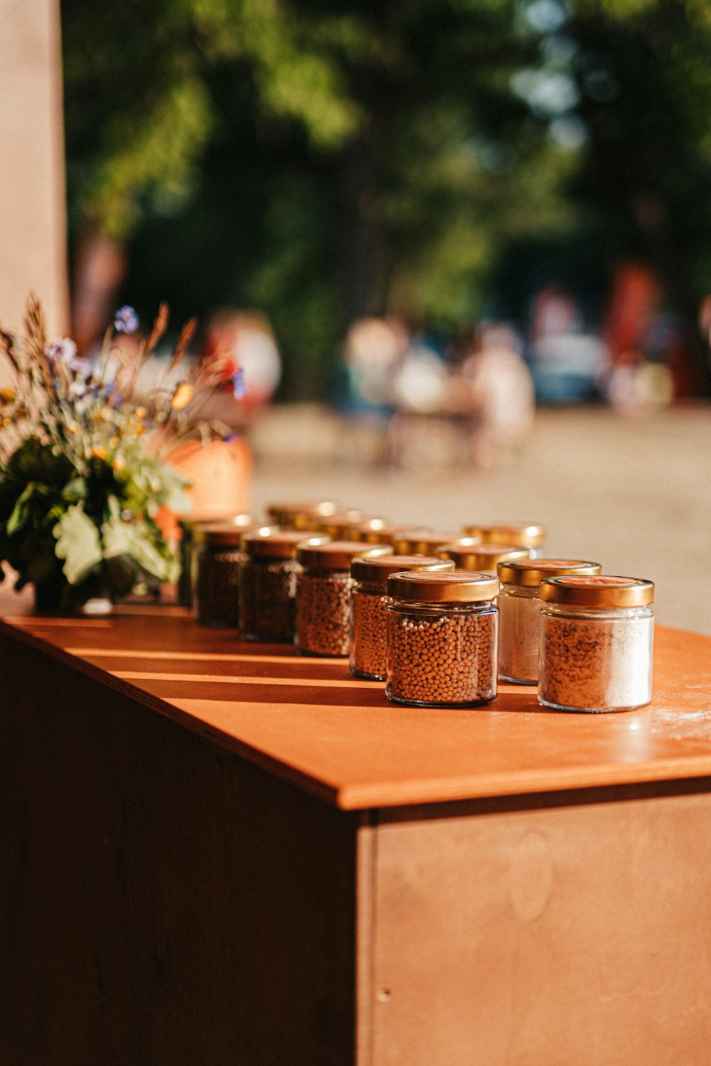 a row of jars sitting on top of a wooden table