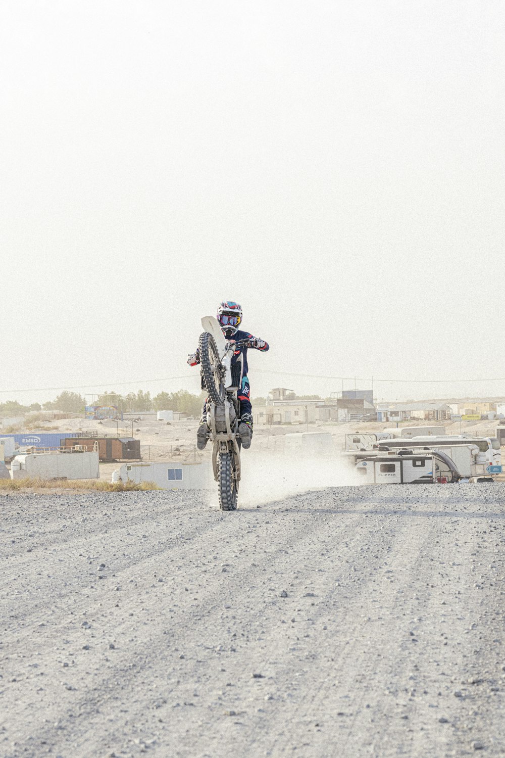 a man riding a dirt bike down a dirt road