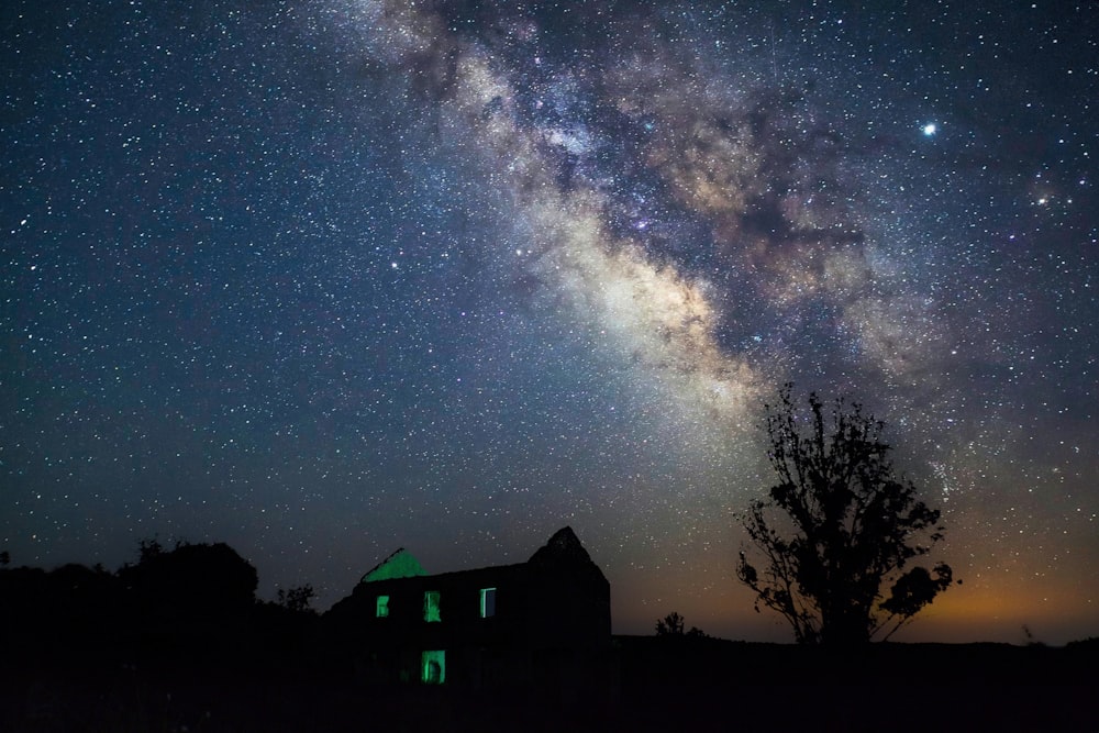 a barn under a night sky filled with stars