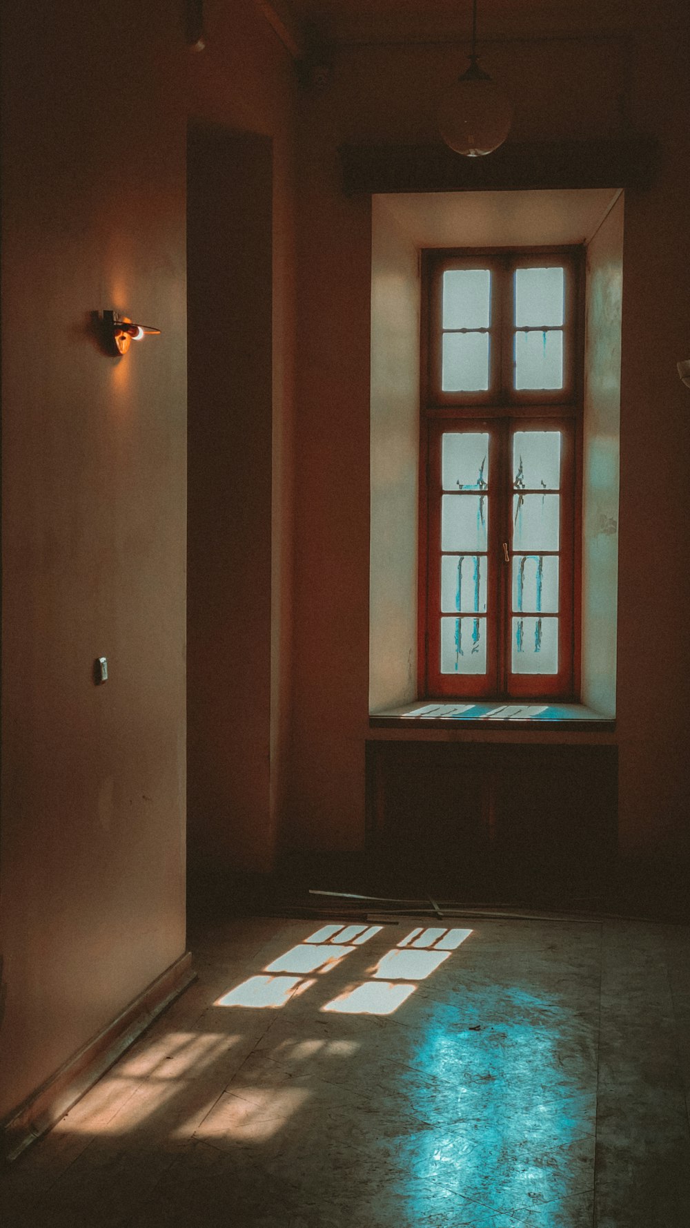 a room with a window and a light coming through the window
