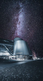 A sleek 3D architectural model of a futuristic space observatory under a starry sky.