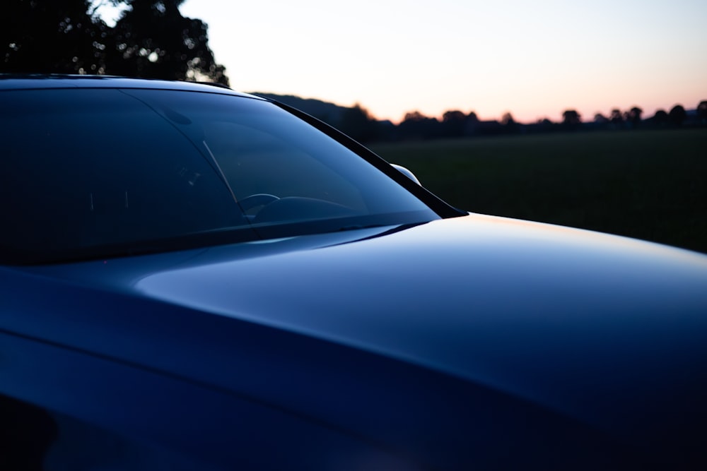 a blue car parked in a grassy field