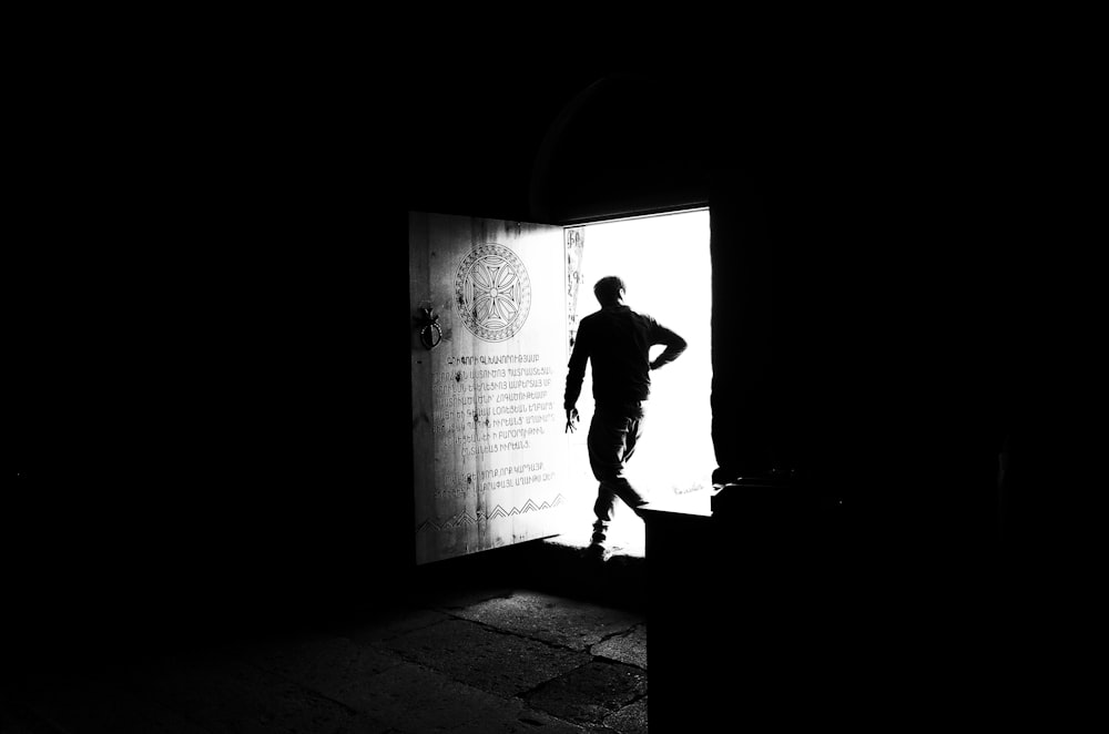 a man standing in a doorway with his hands on his hips