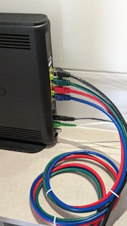 A close-up of high-quality HDMI and USB cables with orange and black accents, neatly arranged on a sleek black surface.