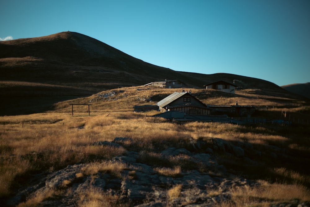 a grassy field with a house on top of it