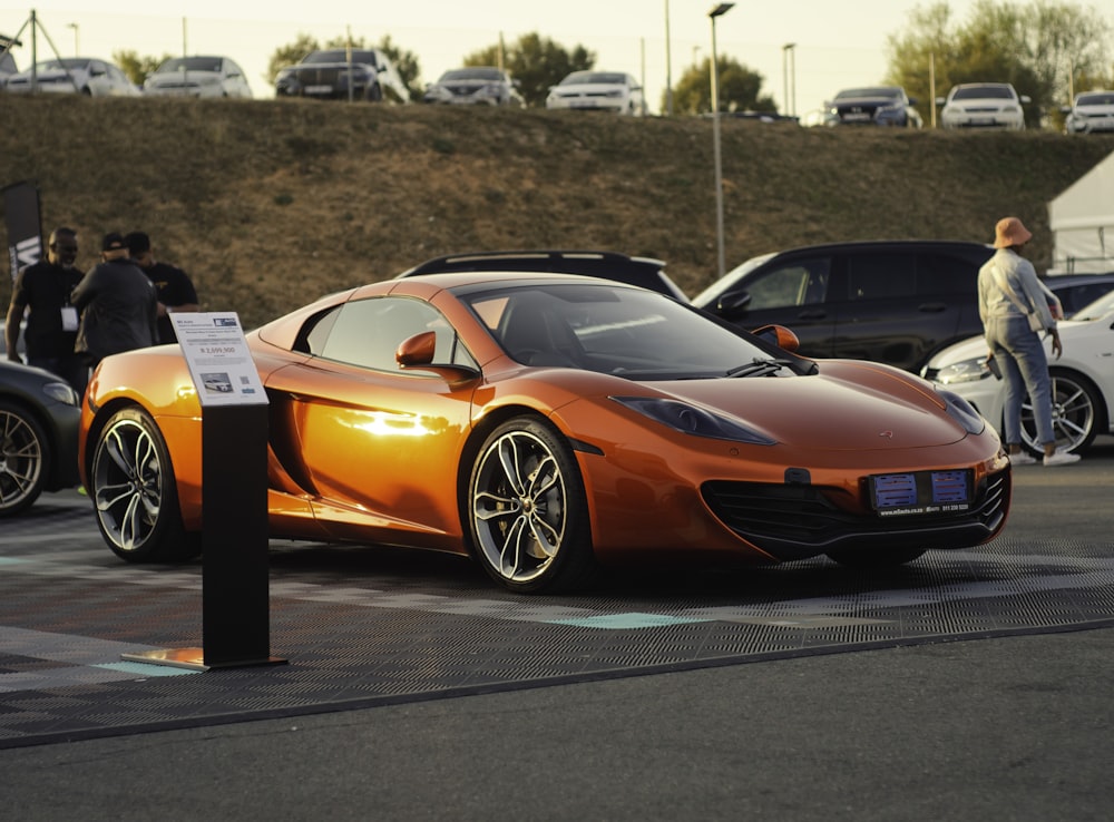 an orange sports car parked in a parking lot