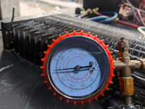 Close-up of a technician carefully checking AC unit components with a digital gauge.
