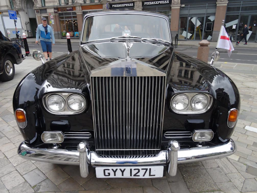 The iconic black and yellow vintage ambassador parked with smoke swirling around, ready to serve.