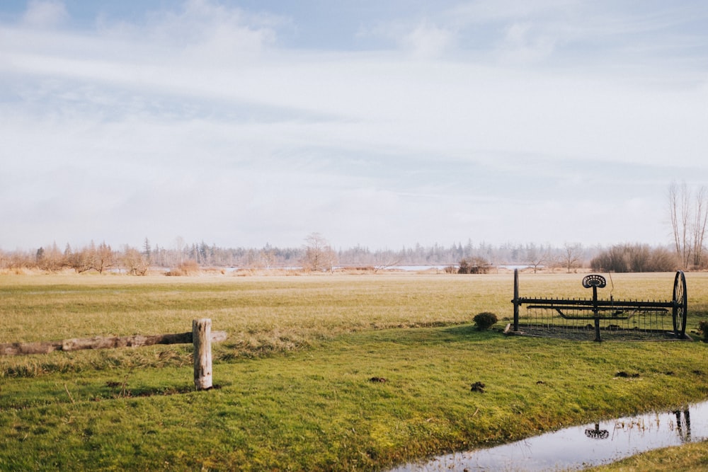 a wooden bench sitting on top of a lush green field