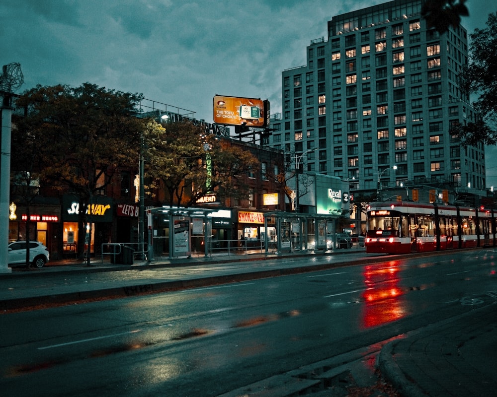 a city street at night with a train on the tracks