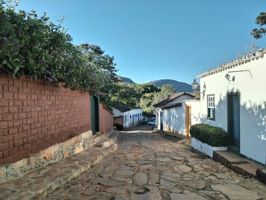 A cobbled street of whitewashed houses below the hills — Tiradentes, Brazil