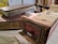 A rustic and worn index card catalog is accompanied by two old, thick books with noticeable aging and distressed covers. The background features a blurred array of books on shelves, enhancing the vintage and library-like ambiance of the scene.