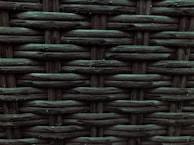A close-up view of a woven pattern with a textured, grid-like structure. The material appears to be a dark, possibly synthetic fiber that crisscrosses to form a rigid surface. Each strand has a slightly glossy finish, adding depth and dimension to the pattern.