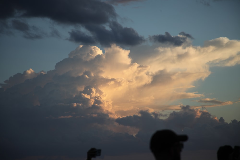 a group of people standing under a cloudy sky