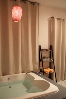 A plush bath mat placed in front of a bathtub with warm lighting.