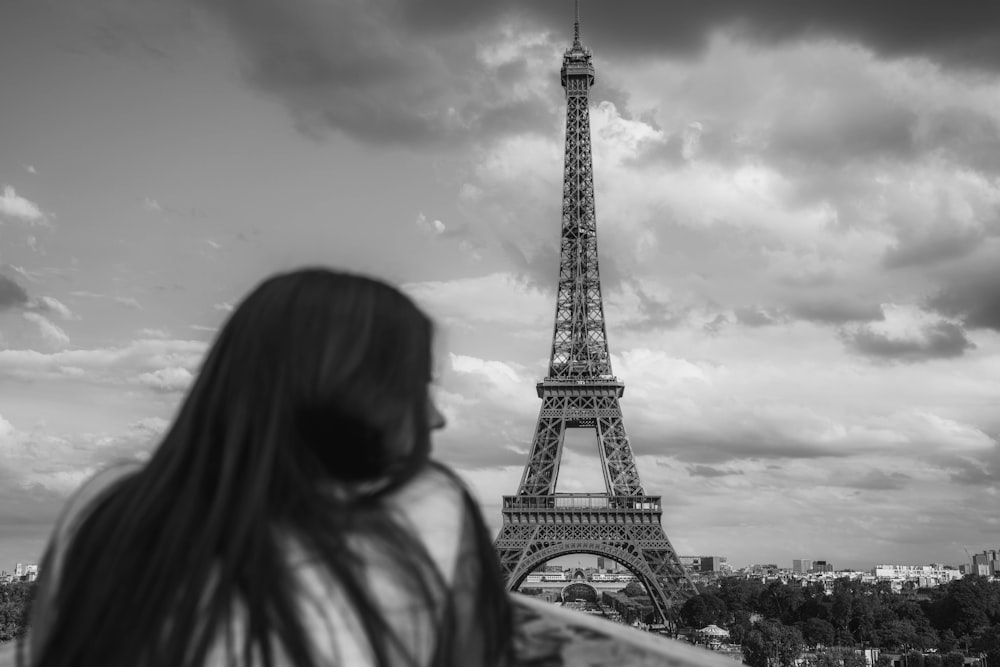 a woman standing in front of the eiffel tower
