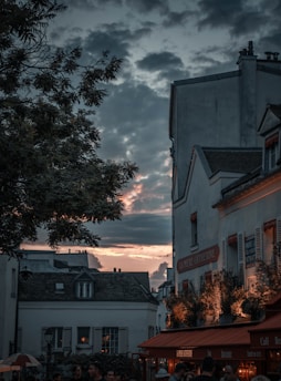 A vibrant street scene in Budapest at sunset, with lively cafes and historic buildings glowing warmly.