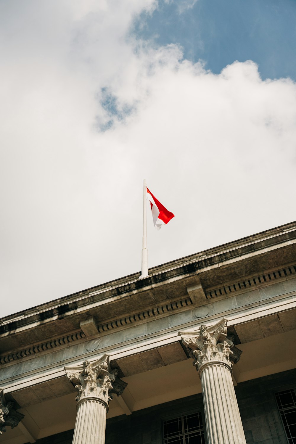 a red and white flag on top of a building