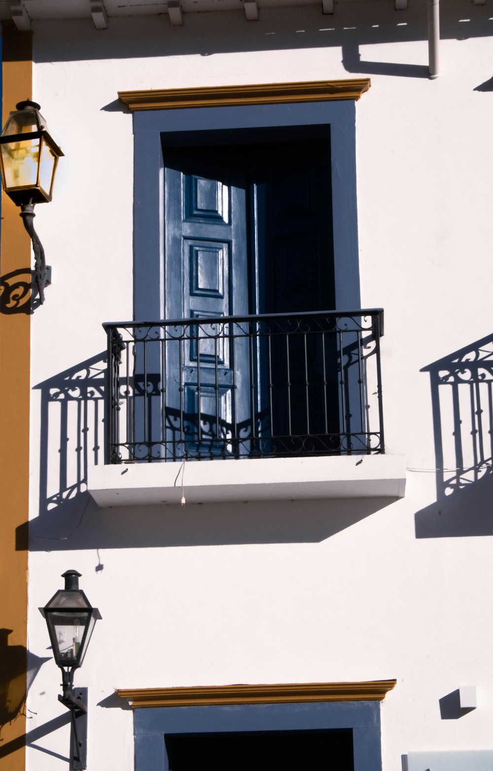 a white building with a black door and balcony