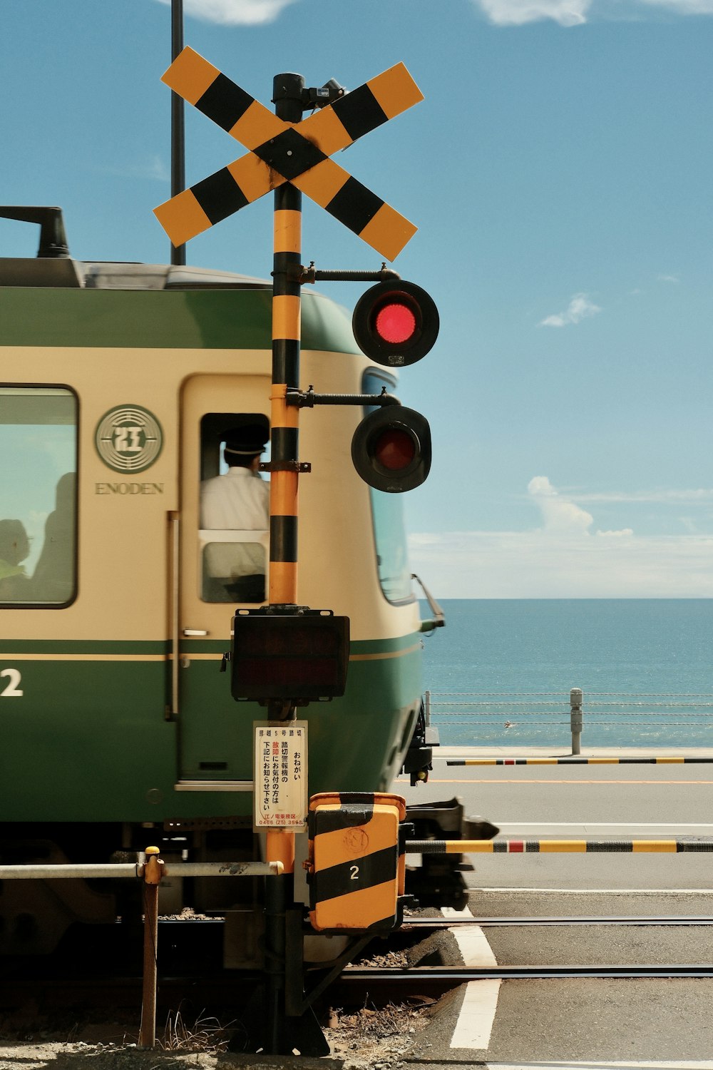 a train stopped at a train station next to the ocean