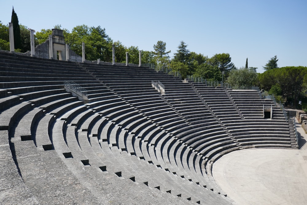 a row of empty seats sitting on top of a cement field