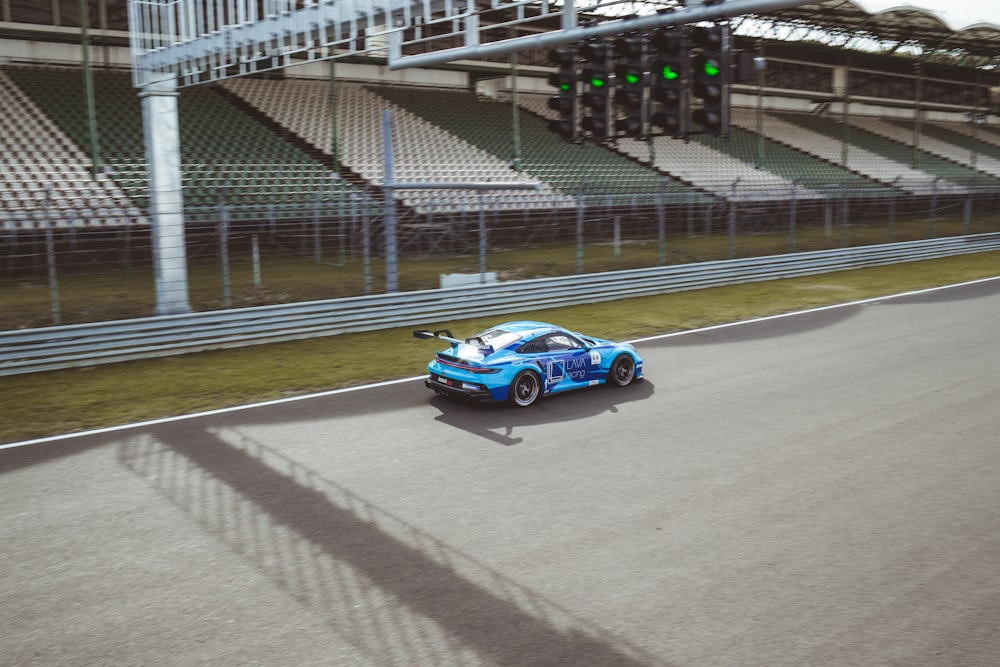 a blue car driving down a race track