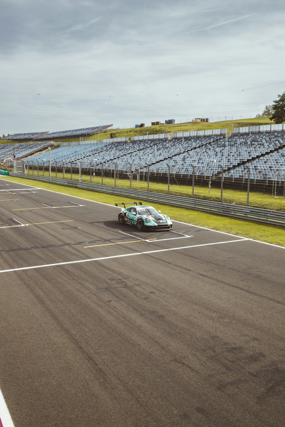 a car driving down a race track with a sky background