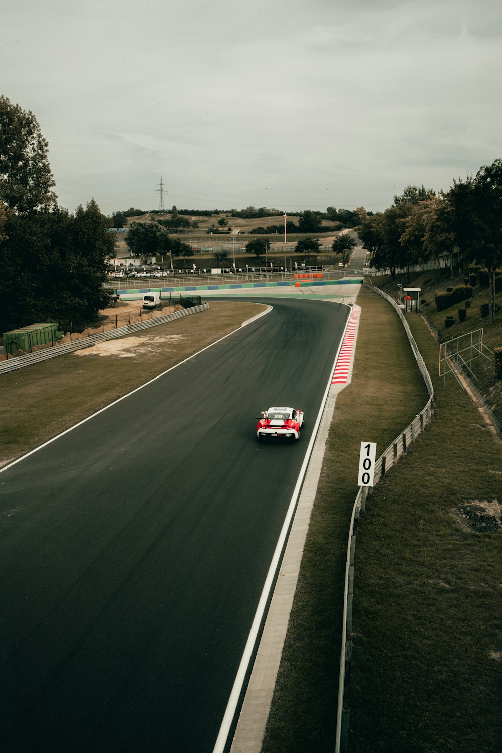 a car driving down a race track on a cloudy day