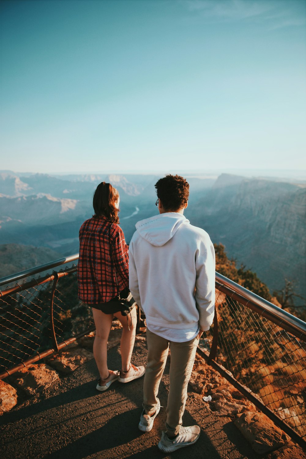 a man and a woman standing on top of a mountain