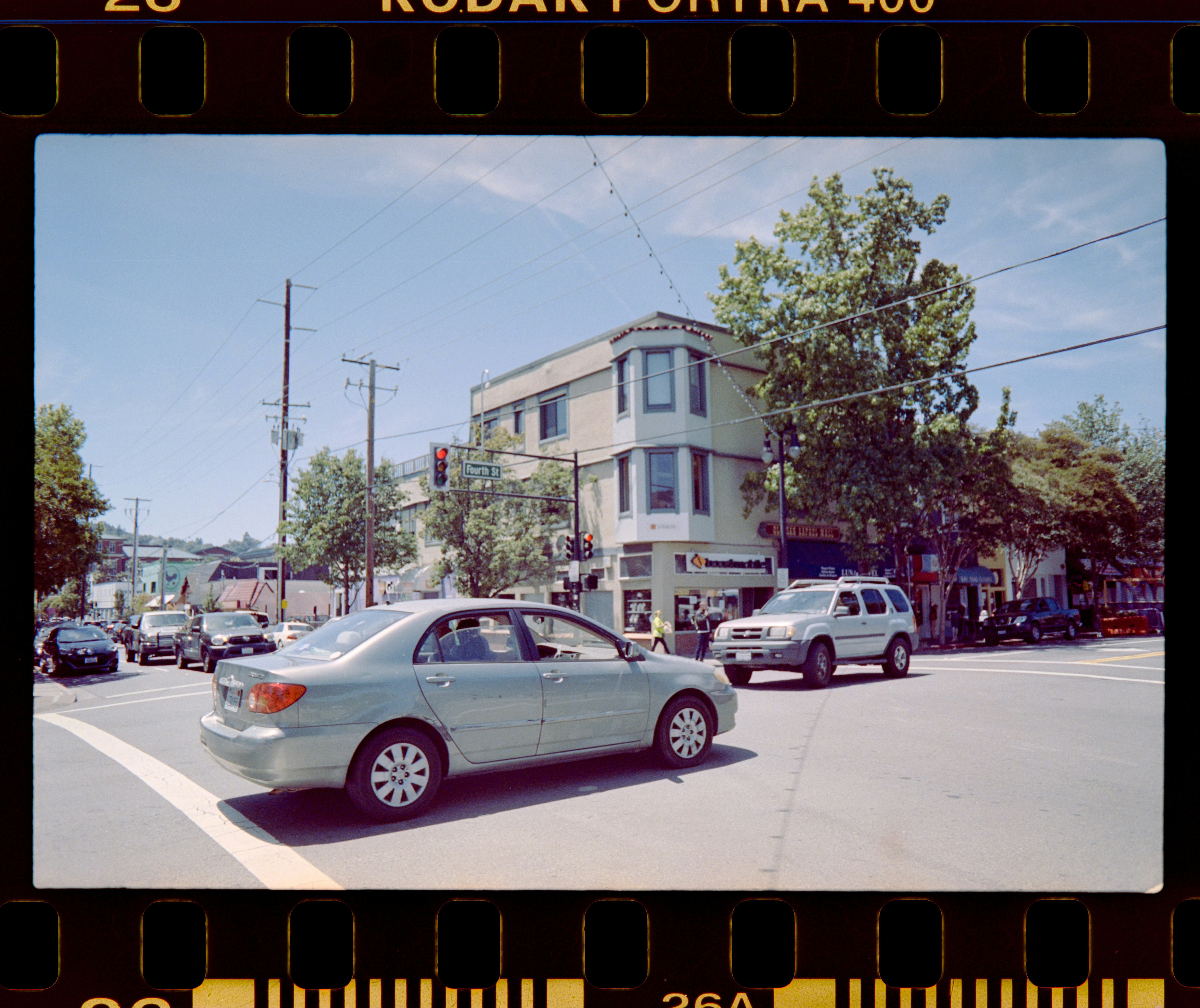 a car driving down a street next to a tall building
