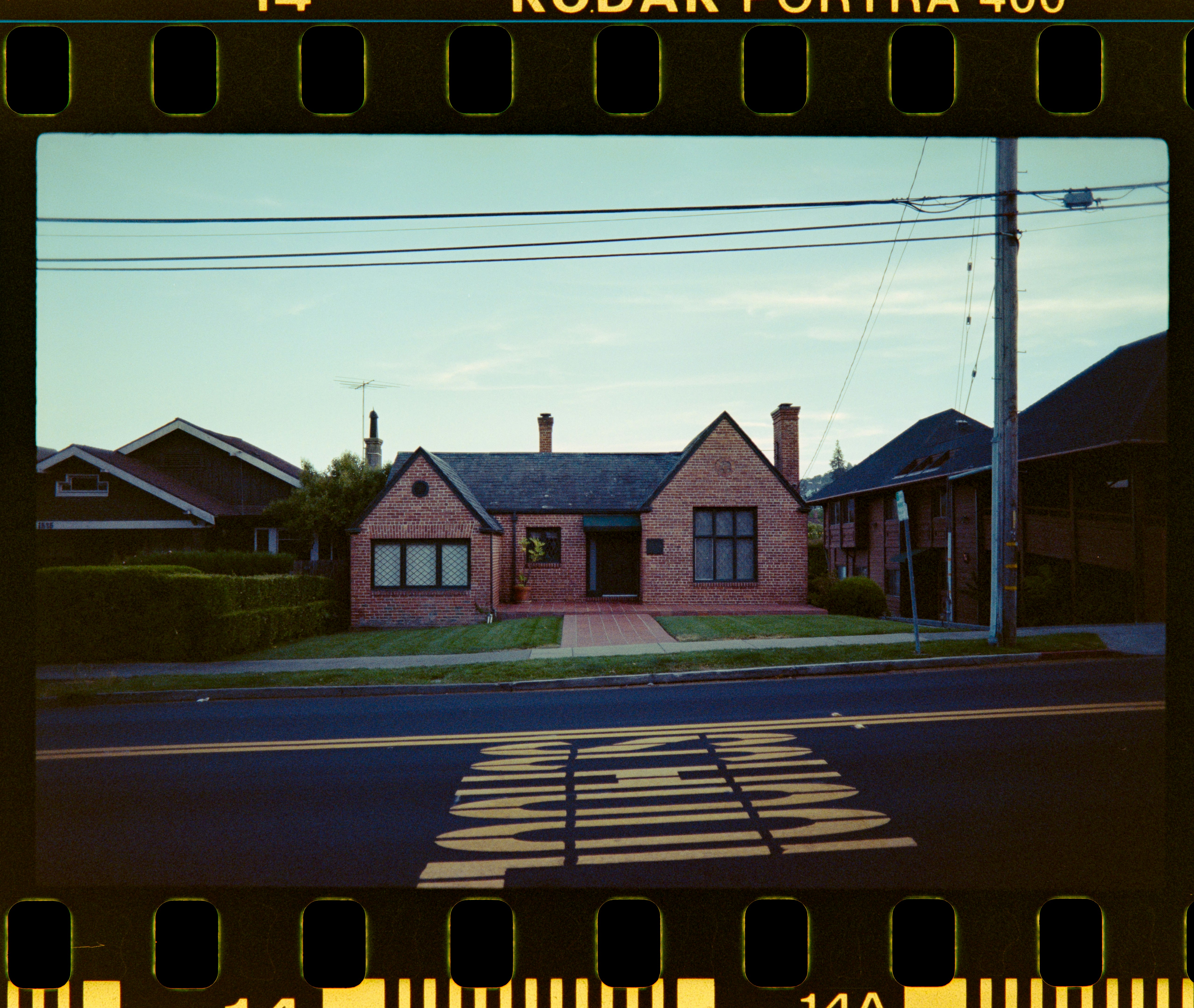a small red brick house sitting on the side of a road