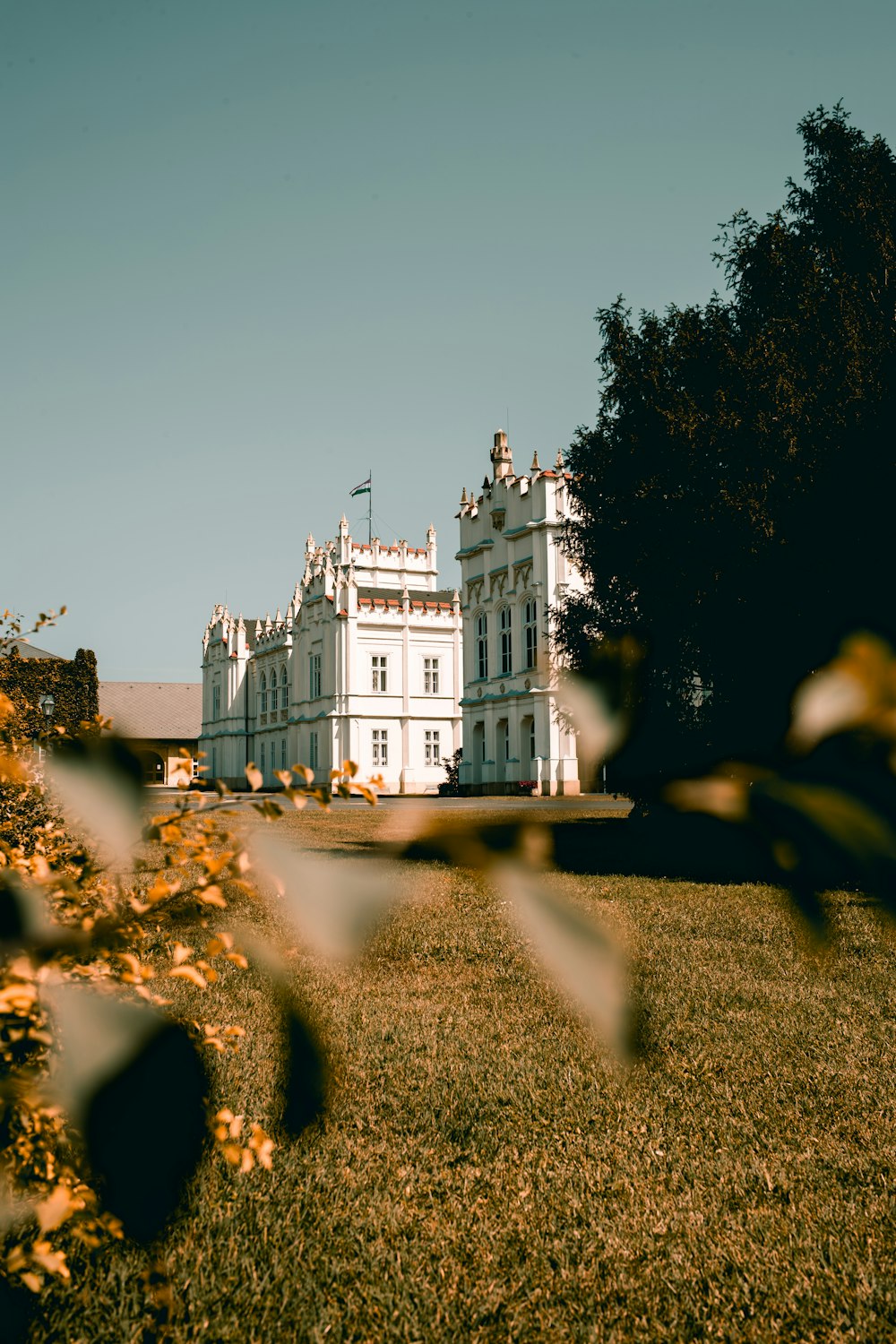 a large white building sitting on top of a lush green field