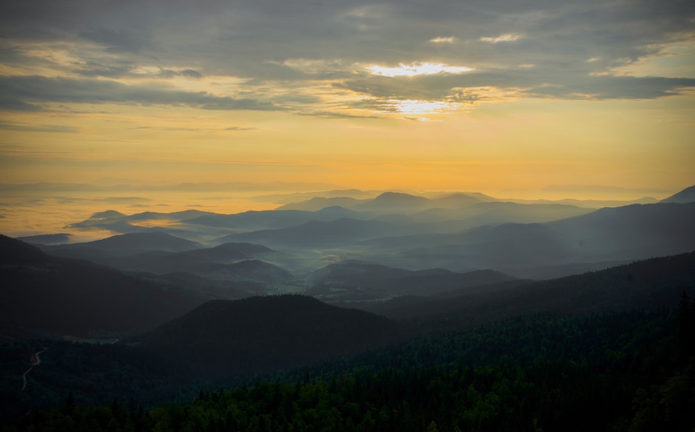 the sun is setting over a mountain range