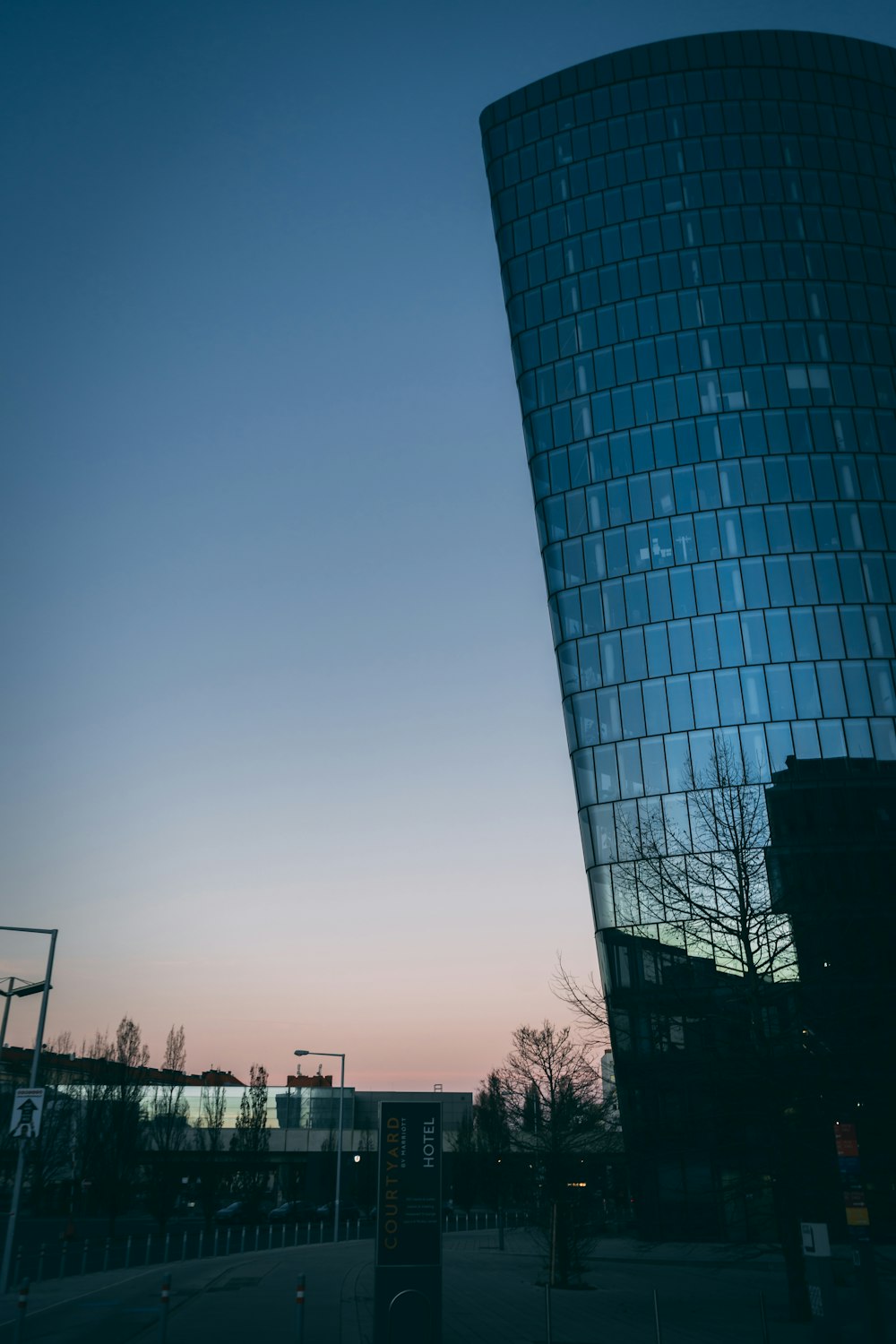 um edifício de vidro alto com um céu ao fundo