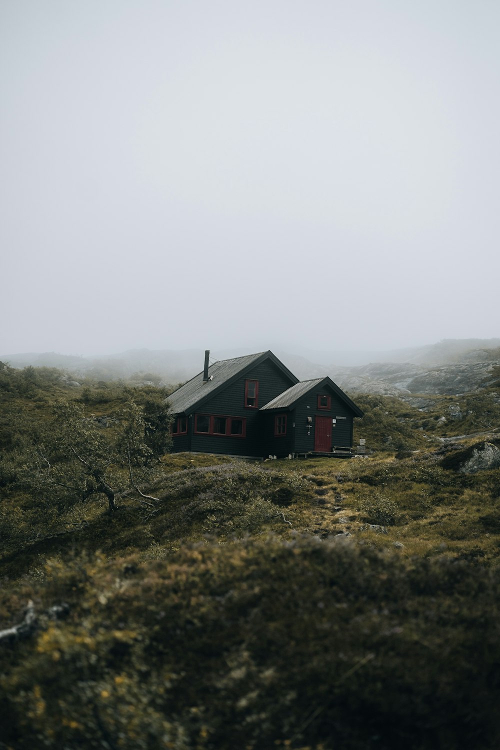 a house on a hill in the middle of a foggy day