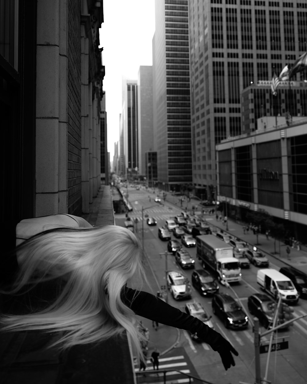 a woman walking down a street next to tall buildings