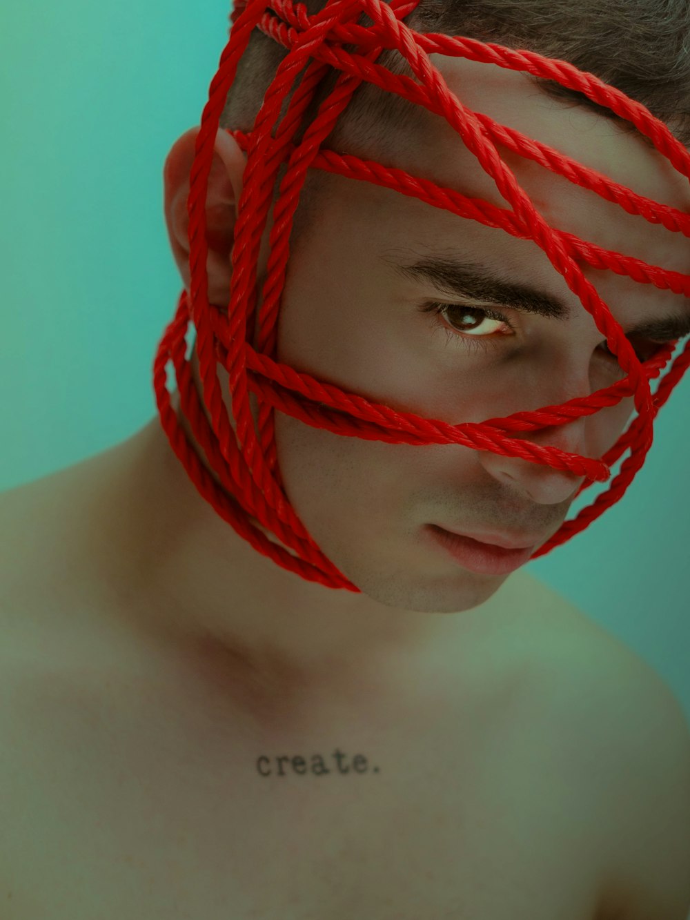 a man with a red string wrapped around his face