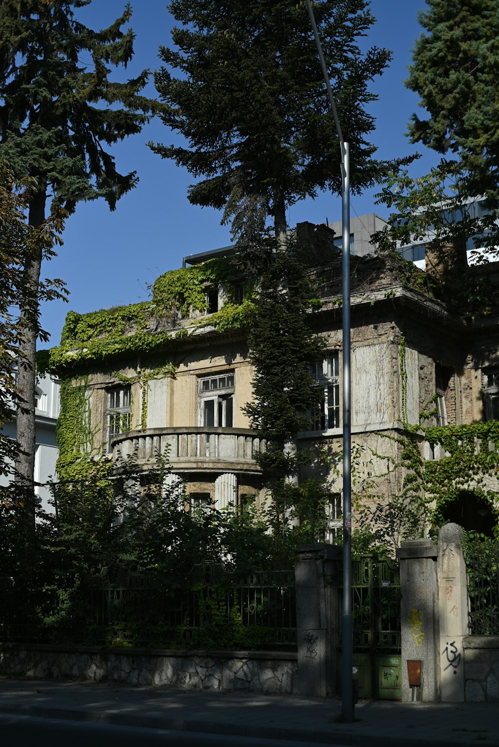 an old building with a green roof surrounded by trees