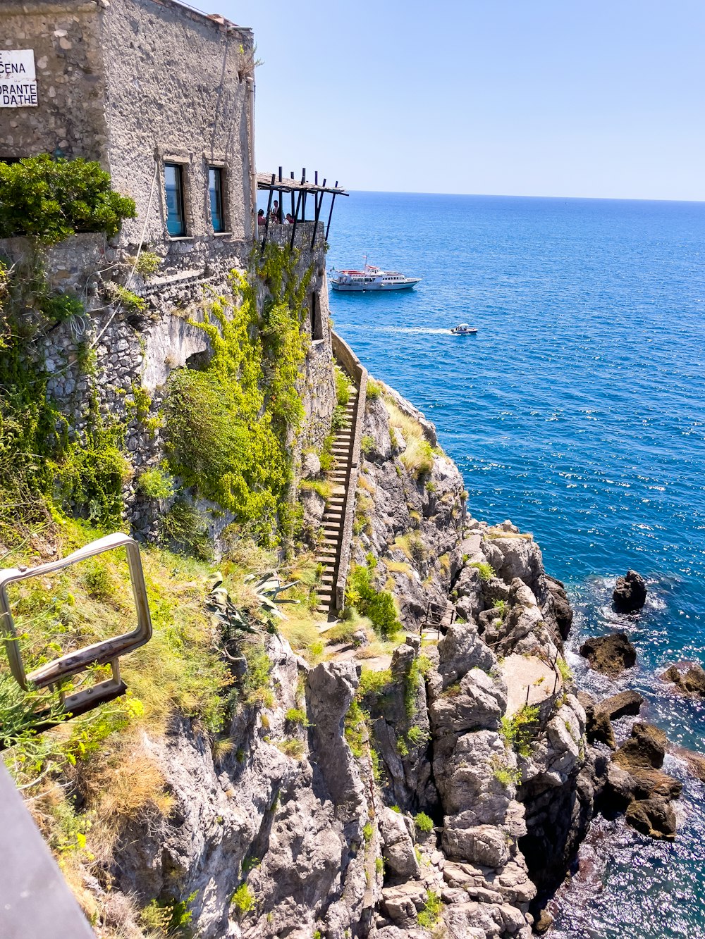 a stone building on the edge of a cliff next to the ocean